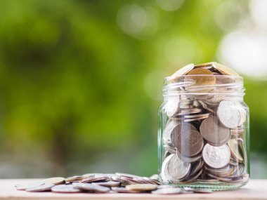 Sikke üzerinde cam kavanoza arka plan bulanıklık. para tasarrufu mali kavramı