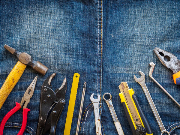 Календарь деревянных блоков 1 мая и столярные инструменты на фоне джинсовой текстуры. Концепция Дня труда
.