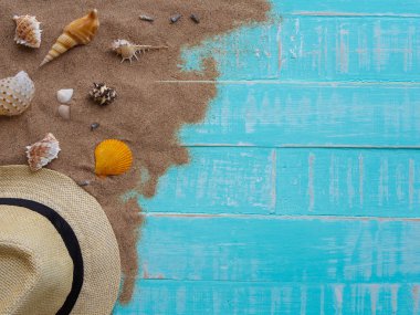 Şapka beach, kabuk, kum parlak dahil plaj aksesuarları pastel ahşap arka plan için yaz tatil ve tatil kavramı mavi.