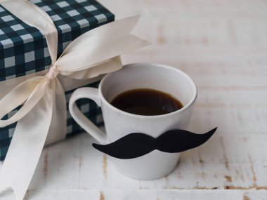 Mutlu babalar günü kavramı. hediye kutusu, bir fincan kahve beyaz zemin üzerine bıyıklı.