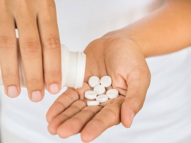 Genç kadın tıp, kapsül veya hap elini dökülen. Sağlık ve tıp kavramı.