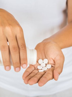 Genç kadın tıp, kapsül veya hap elini dökülen. Sağlık ve tıp kavramı.