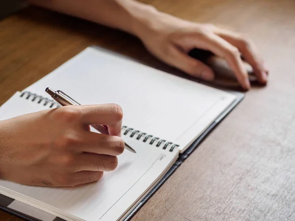 Close Mãos Homem Escrevendo Notebook Colocado Área Trabalho Madeira Negócio — Fotografia de Stock