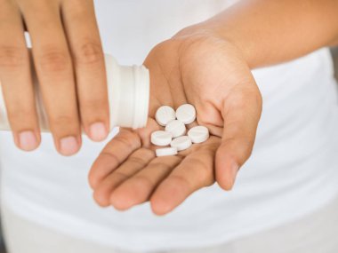 Genç kadın tıp, kapsül veya hap elini dökülen. Sağlık ve tıp kavramı.