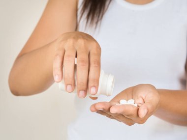 Genç kadın tıp, kapsül veya hap elini dökülen. Sağlık ve tıp kavramı.