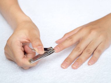 Beyaz arka plan üzerinde tırnak makası kullanarak tırnak kesme kadın. Sağlık ve yaşam tarzı kavramı.