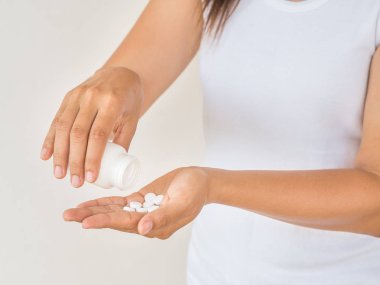 Genç kadın tıp, kapsül veya hap elini dökülen. Sağlık ve tıp kavramı.