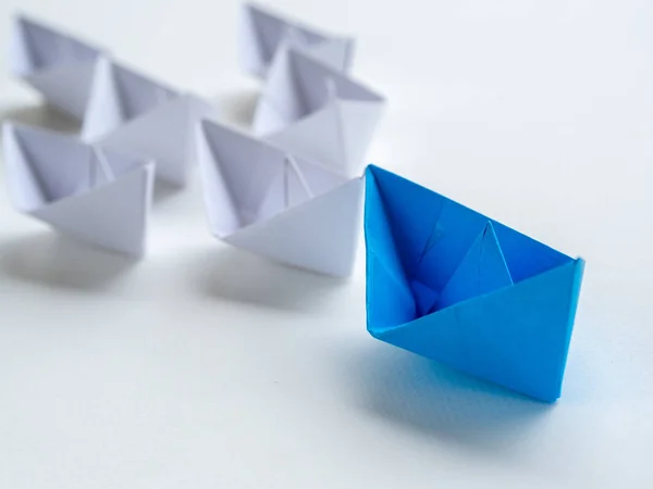 Liderlik kavramı. mavi kağıt gemi baş beyaz arasında. Bir lider gemi gemi yol açar..