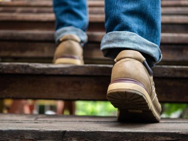 Ahşap merdivenlerden yukarı yürümek yetişkin adam. Hareketli ileri kavramı.