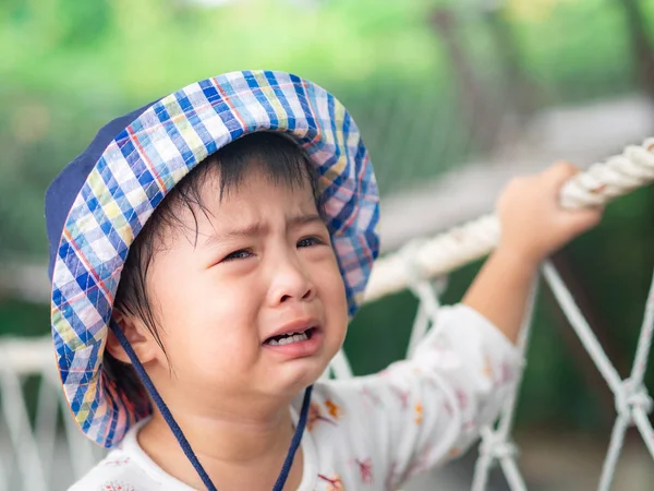 Bokeh arka yüzünde vintage filtre ile ağlayan üzgün küçük kız. Üzgün, mutsuz, depresif kavramı.