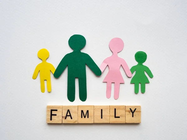 Family symbol mad with paper and text FAMILY woodenblock on white paper background. Family concept.