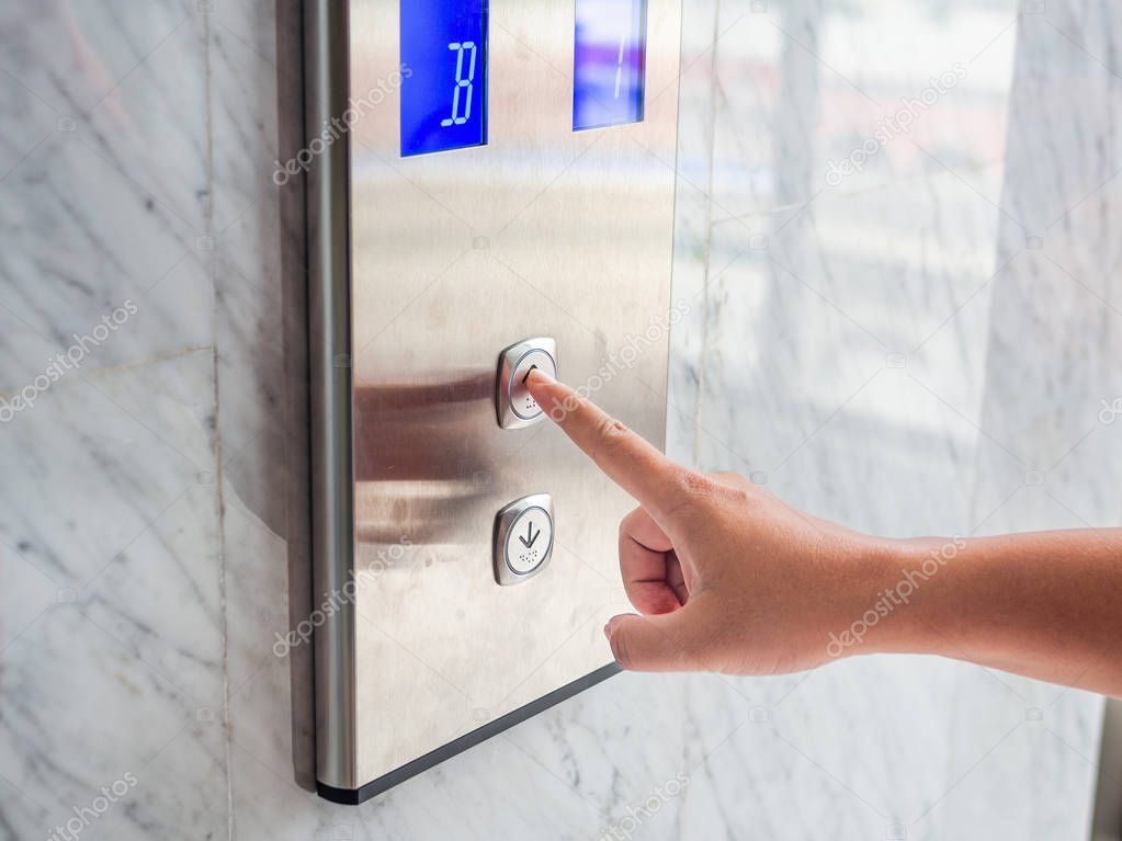 Close up man hand press a up button of elevator inside the building for upper high level floor.