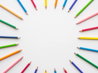 Oval şekli ile Beyaz Kağıt arka plan üzerinde renkli kalemler. Eğitim ve okul kavramı dön.