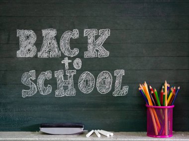 Geri okul kavramı. İleti örneği ve yazı tahtası önünde dizüstü bilgisayarlar ile okul çantası.