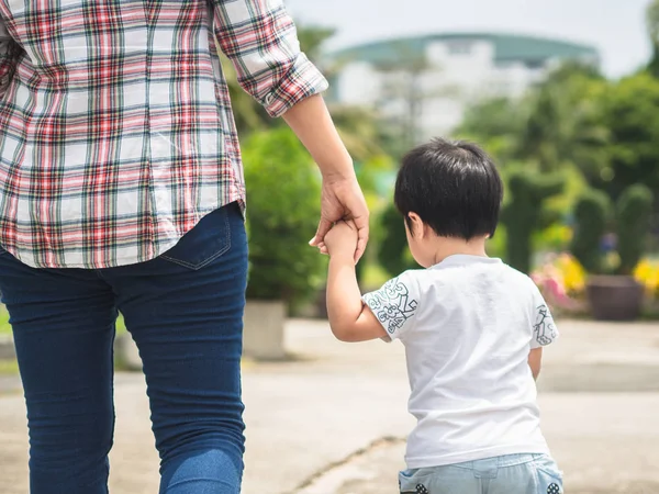 母女牵着手在公园里散步 孩子和妈妈的家庭概念 — 图库照片