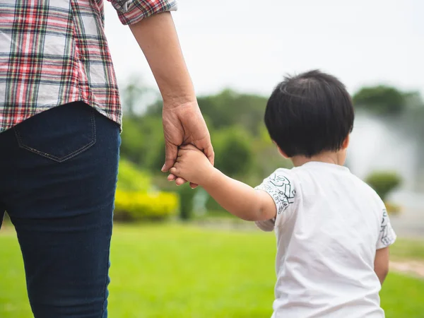 母女牵着手在公园里散步 孩子和妈妈的家庭概念 — 图库照片