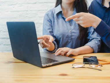 Genç adam ve ofiste çalışan kadın. İş adamı labtop işaret. Coworking, takım çalışması, iş ortağı kavramı.