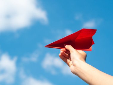 Kırmızı kağıt roket mavi gökyüzü arka plan ile tutan kadın el. Özgürlük kavramı