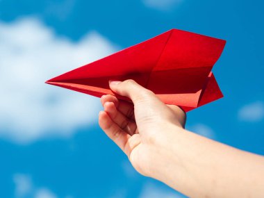 Kırmızı kağıt roket mavi gökyüzü arka plan ile tutan kadın el. Özgürlük kavramı