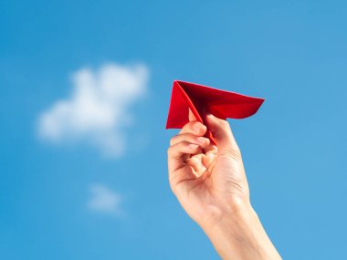 Kırmızı kağıt roket mavi gökyüzü arka plan ile tutan kadın el. fr
