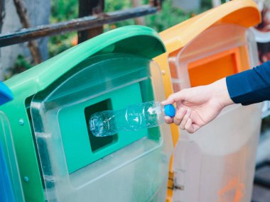 Adam el recyc içinde boş plastik su şişesi atarak closeup