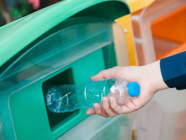 Adam el recyc içinde boş plastik su şişesi atarak closeup