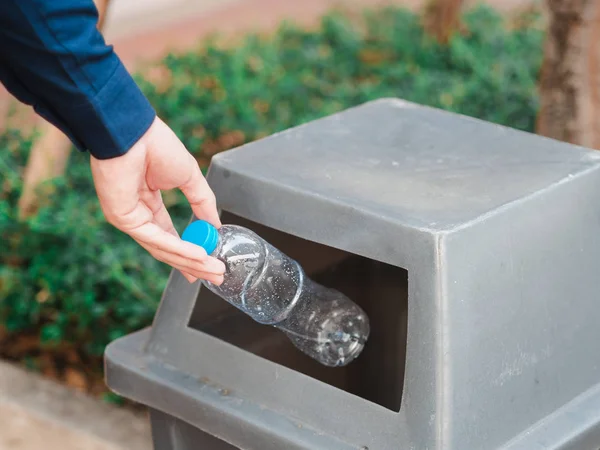 Polárszűrő az ember kezét üres műanyag vizes palackot dobott egy bin — Stock Fotó