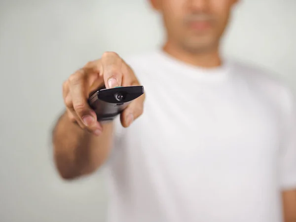 Closeup of a man pess the remote controller button on white back — Stock Photo, Image