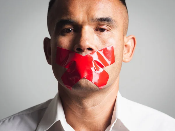 Man is silenced with adhesive red tape across his mouth sealed t