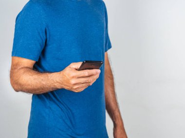 Beyaz arka planda izole edilmiş akıllı telefon kullanan genç bir adam.