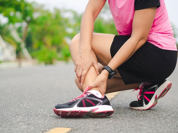 La mujer atleta sufre lesiones de tobillo, derrame la pierna durante la ejecución de trai. — Foto de Stock