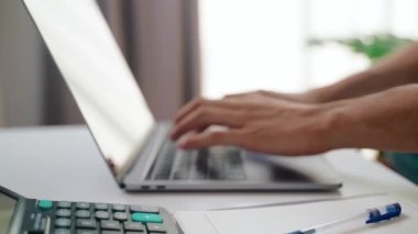 Evdeki iş için dizüstü bilgisayarın klavyesine yazı yazan bir adamın yakın çekimi. Ev kavramından çalış.