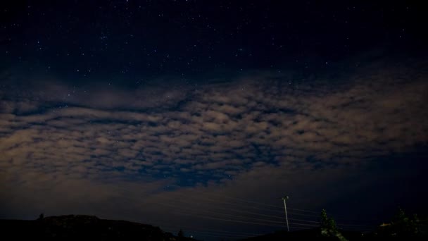 Un lapso de tiempo nocturno con un cielo nublado y estrellas — Vídeo de stock