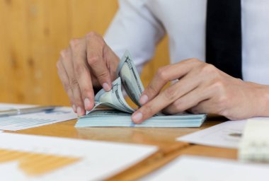 Tonda resim, Erkekler dolar banknotları saymak için elleri kullanarak