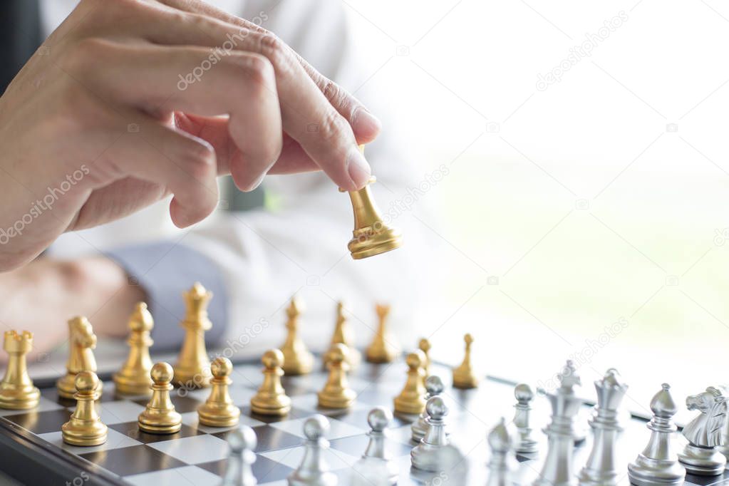 A young business man is playing chess, business strategy to be s