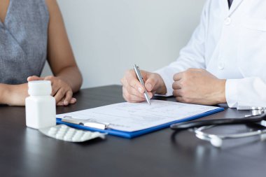 Doktor şu anda hastanın hastalığının tedavisi, teşhisi ve tıbbi danışma konsepti hakkında danışmanlık yapıyor..