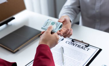 İşadamları, yasadışı arazi ve gayrimenkul, iş dolandırıcılığı ve sosyal adaletsizlik, yolsuzluk ve rüşvet kavramını satın almak için sözleşmeler imzalayan çalışanlara dolar dağıtıyor.