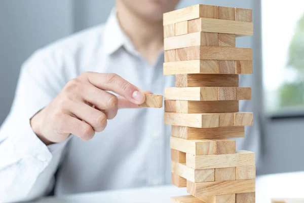 Business people play wooden games, divide the average investment value of a business and jointly manage risks, Alternative risk plan and strategy in business.