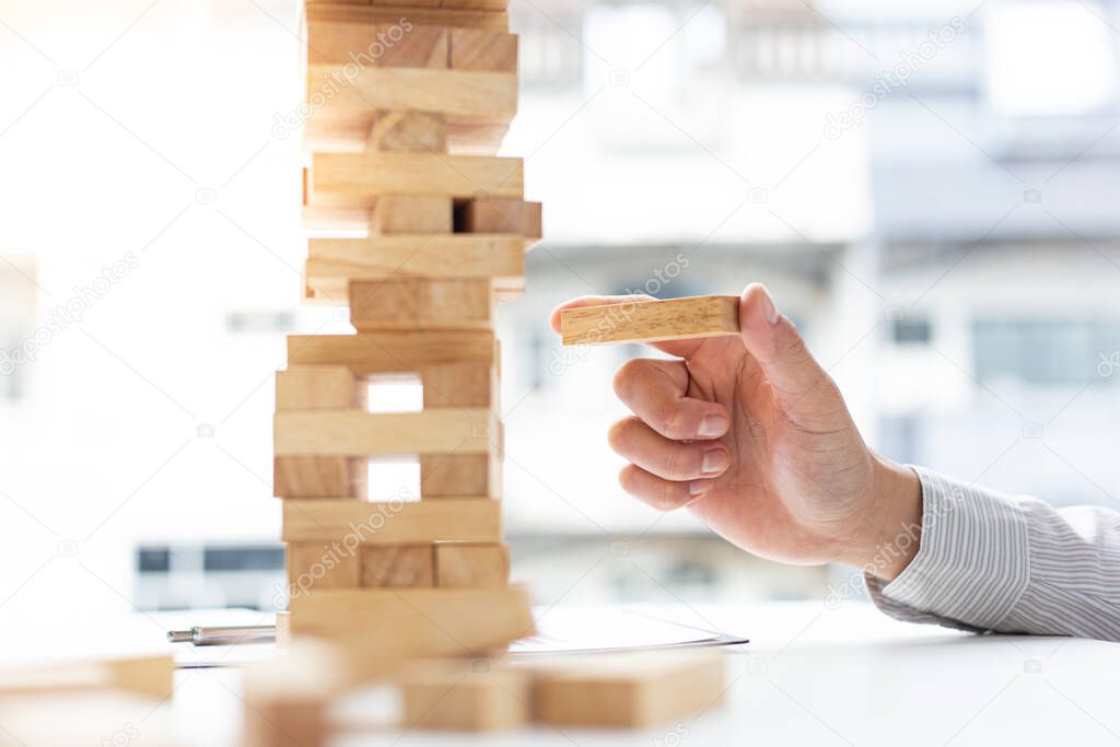 Business people play wooden games, divide the average investment value of a business and jointly manage risks, Alternative risk plan and strategy in business.
