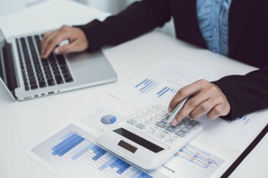İş kadınları finans ve pazar verilerini iş yerinde grafikler ve dizüstü bilgisayarlarla, İş Finansmanı Bankacılık ve vergi sistemi kavramlarıyla hesaplıyor ve analiz ediyorlar..