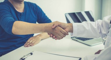 Doktorlar ve hastalar, tebrikleri ve başarı kavramını geliştiren ve iyileştiren tedavi sonuçlarının ardından el sıkıştılar..