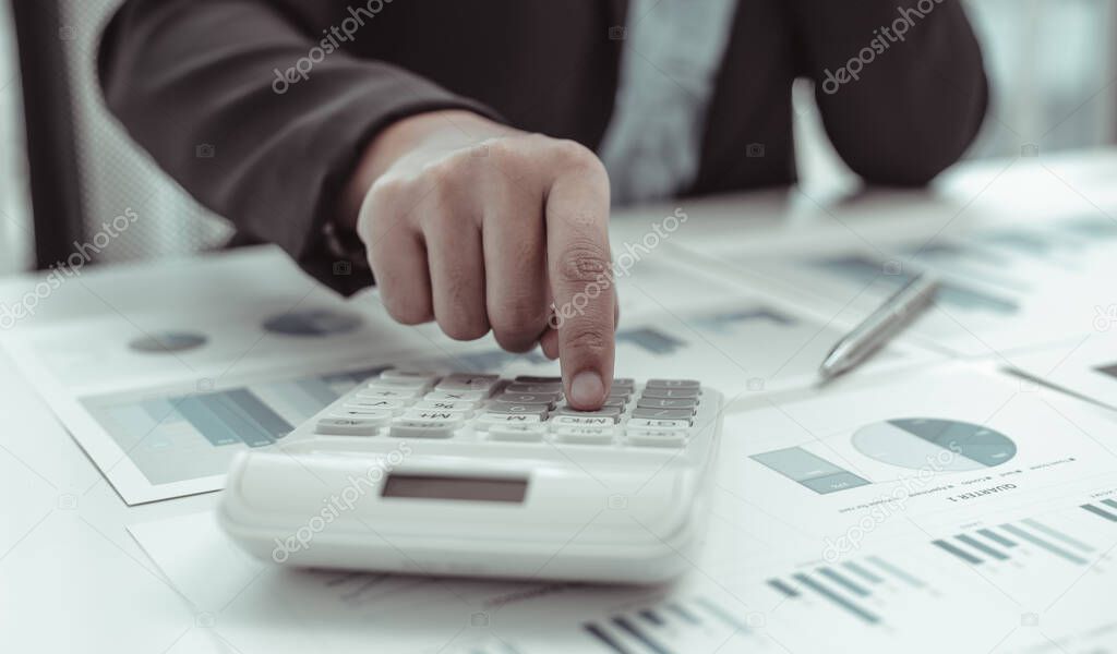 Businesswomen are calculating finances and analyzing market data with graphs and laptops at work, Business Financing Accounting Banking and tax system Concept.