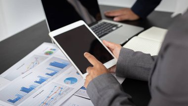 Beyin fırtınası ekibi, pazarlamacılar ve finans danışmanları müşteri ihtiyaçları, bilgisayar ve iş konsepti için tablet teknolojisini karşılayacak stratejiler planlamak ve planlamak için grafikleri tartışıyor..