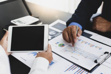 Beyin fırtınası ekibi, pazarlamacılar ve finans danışmanları müşteri ihtiyaçlarını karşılamak için stratejiler, iş konsepti için Tablet teknolojisini tartışmak ve analiz etmek için grafikler hazırlıyorlar..