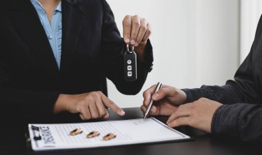 Araba satıcısı ya da yönetici, araba satın alma belgelerini sigorta, belge imzalama ve kredi onayı ile imzalayan müşterilere anahtar verir.