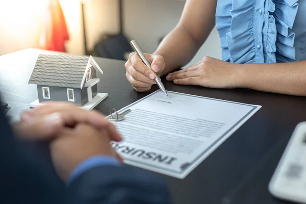 부동산 중개업자 매니저는 부동산 계약서에 보험에 서명하는 고객들에게 조건과 조건을 — 스톡 사진