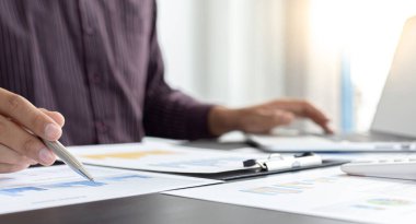 Bağımsız finans işadamları müşterinin yıllık gelirini hesaplar ve ofis grafikleri, Gelir Vergisi Yönetimi ve Mali Muhasebe konseptiyle pazarı derinlemesine analiz eder.