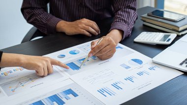 İş dünyası ekibi toplantısı mevcut, iş adamları ve yatırımcılar çalışmalarını finans yöneticileri, finans muhasebe ve Tex 'e sunmak üzere yıllık gelir veri grafiklerini inceliyor ve analiz ediyorlar.