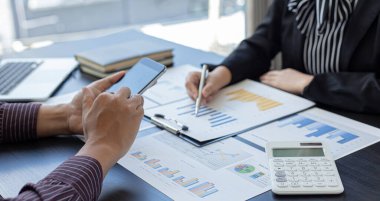İş dünyası ekibi toplantısı mevcut, iş adamları ve yatırımcılar çalışmalarını finans yöneticileri, finans muhasebe ve Tex 'e sunmak üzere yıllık gelir veri grafiklerini inceliyor ve analiz ediyorlar.