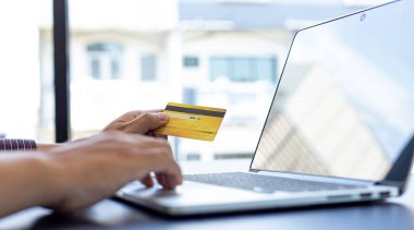 İş adamları internet üzerinden kredi kartı ödemelerini, teknoloji ve İnternet 'te rahatlığı, online alışveriş ve online bankacılık kavramını kullanarak online alışverişleri kaydetmek için dizüstü bilgisayar kullanıyorlar..